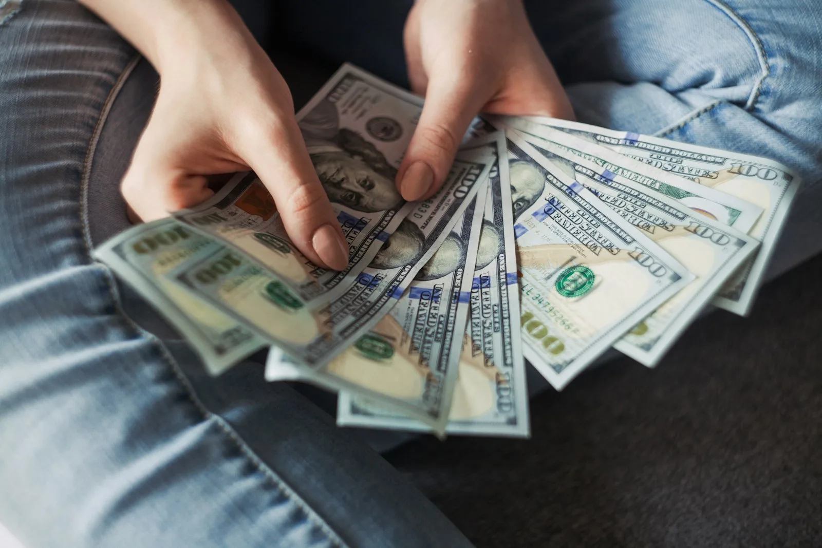Hands holding a fan of US dollar bills
