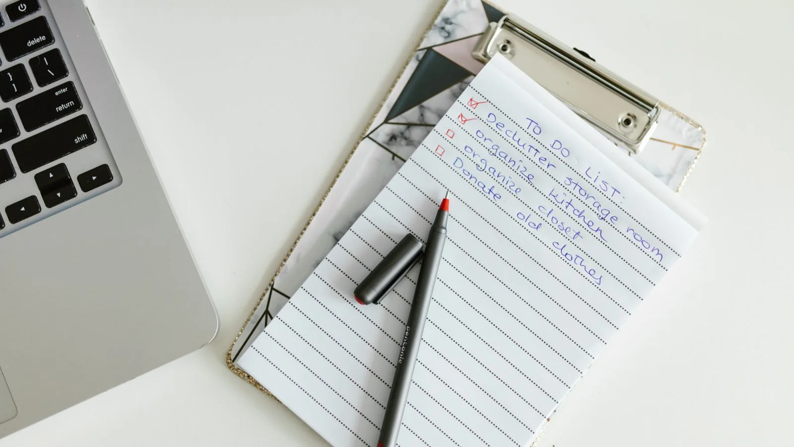 A neatly organized to-do list on a clipboard next to a laptop and pen, conveying productivity.