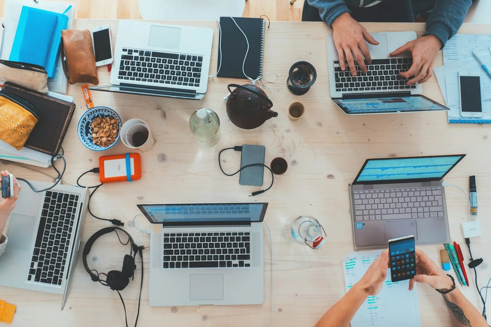 Overhead view of a desk covered in laptops, phones and gadgets