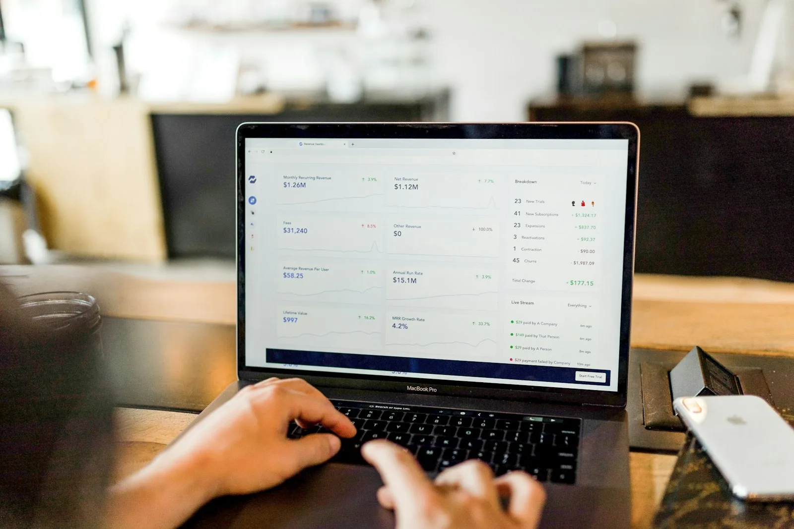 Hands typing on a laptop showing a task list application