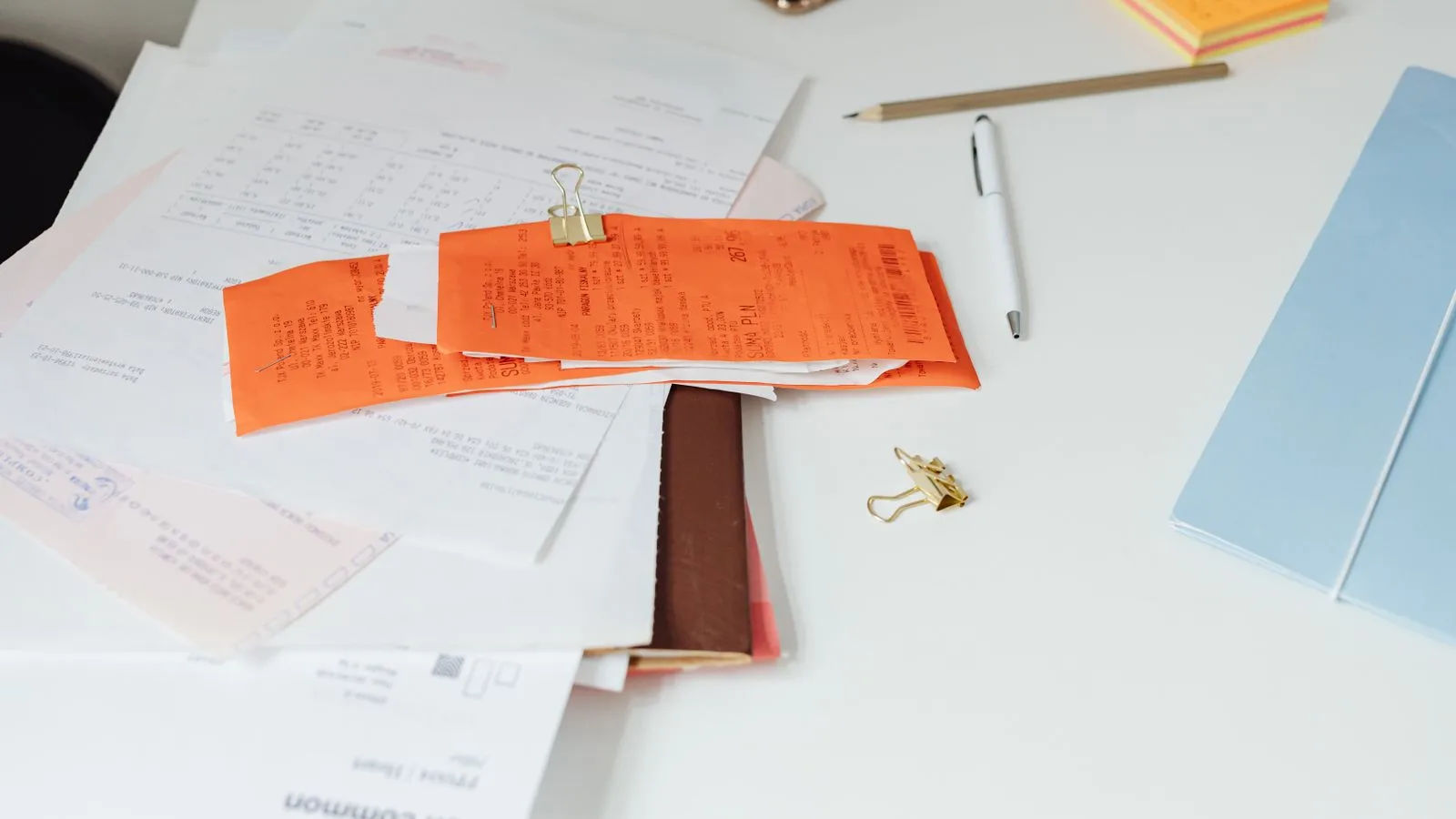 Close-up of a tidy desk with receipts, documents, and office stationery for business organization.