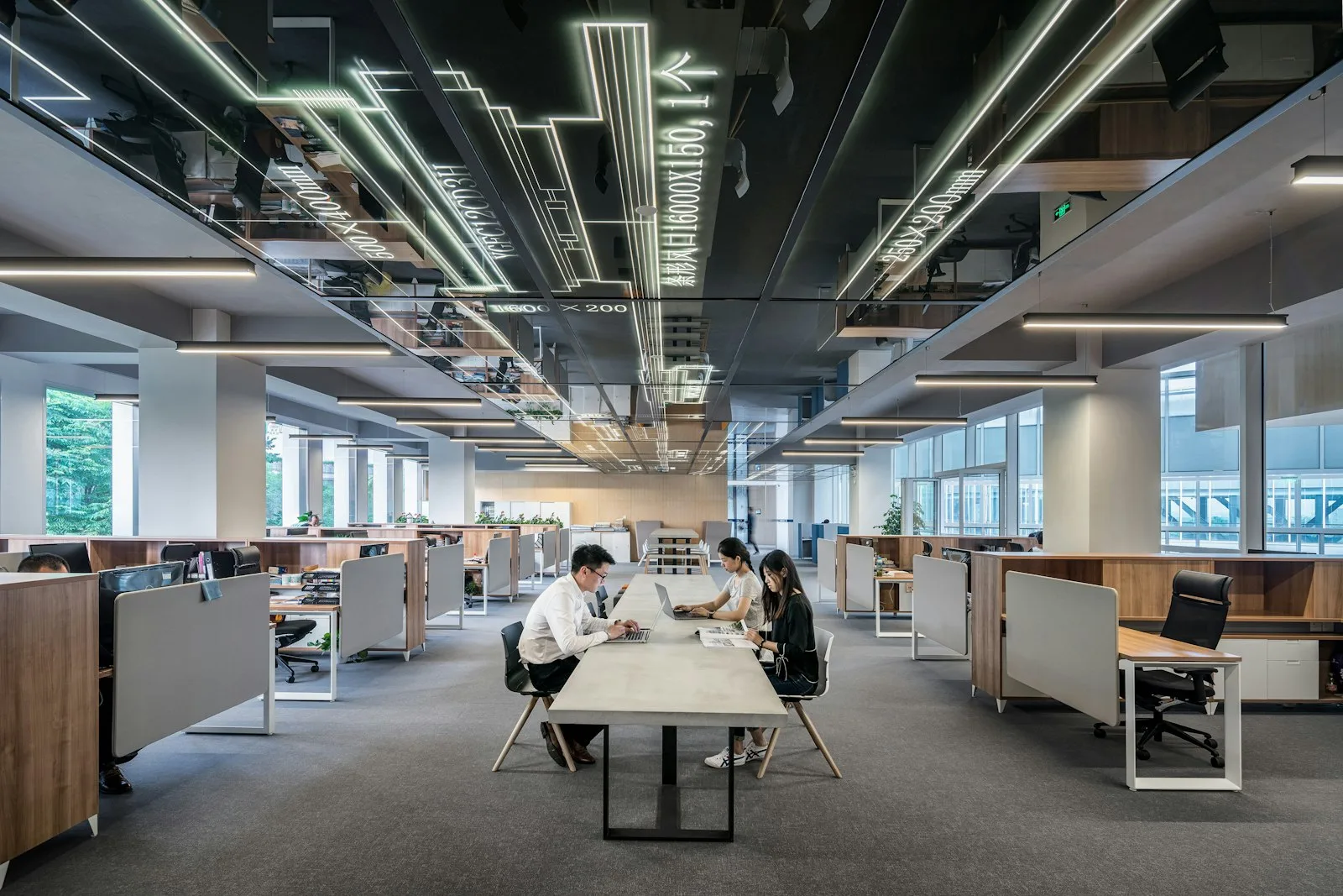 A modern open-plan office with employees working at long desks