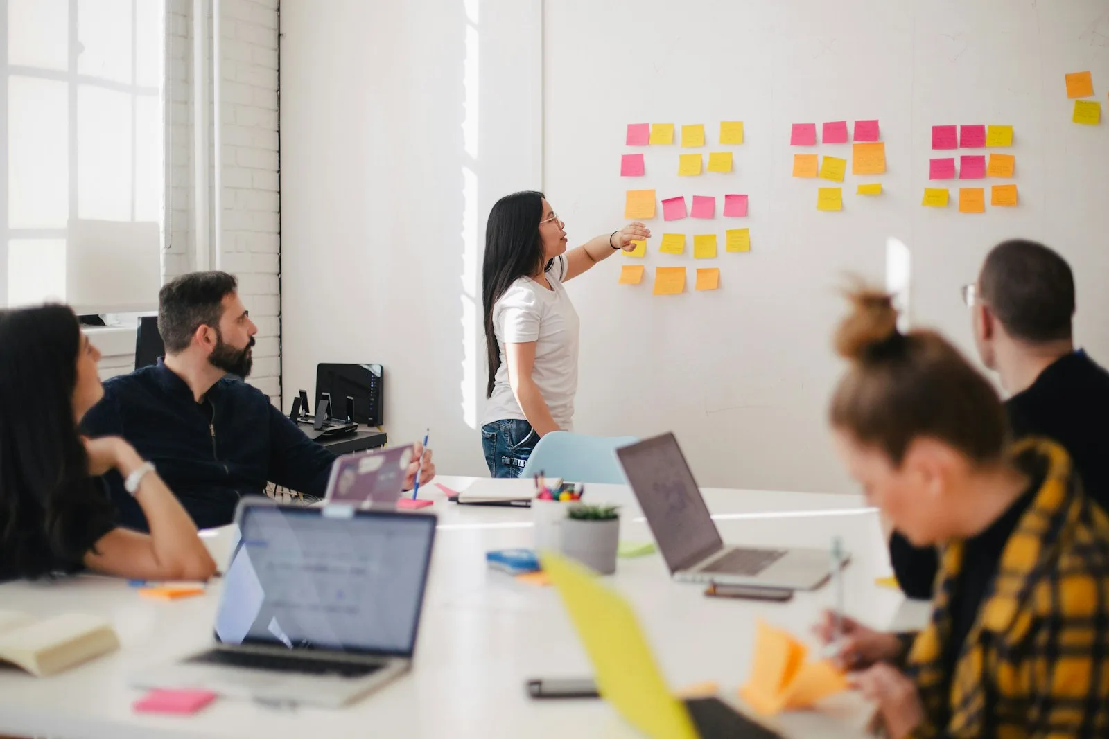 A team standing in front of a wall of sticky notes during a retrospective