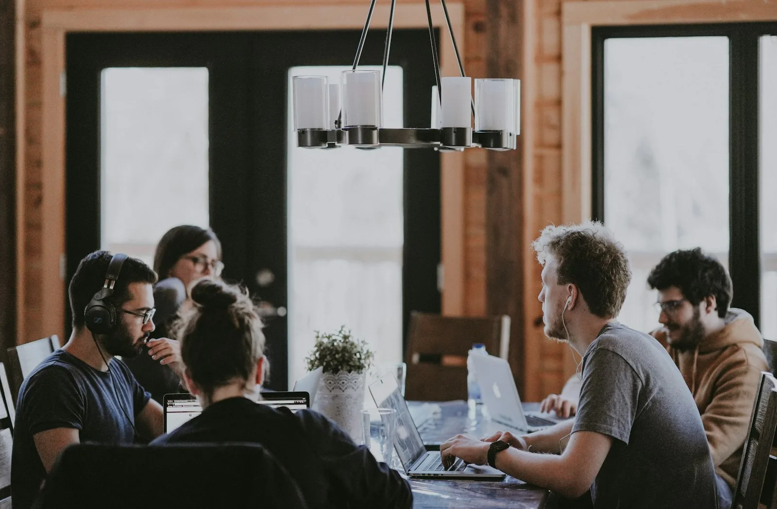 A small team collaborating around a table in a bright wood-paneled office